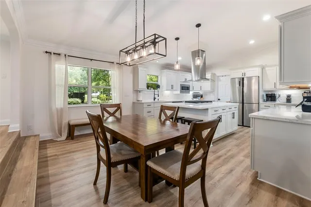 a view of a dining room with furniture a chandelier and wooden floor