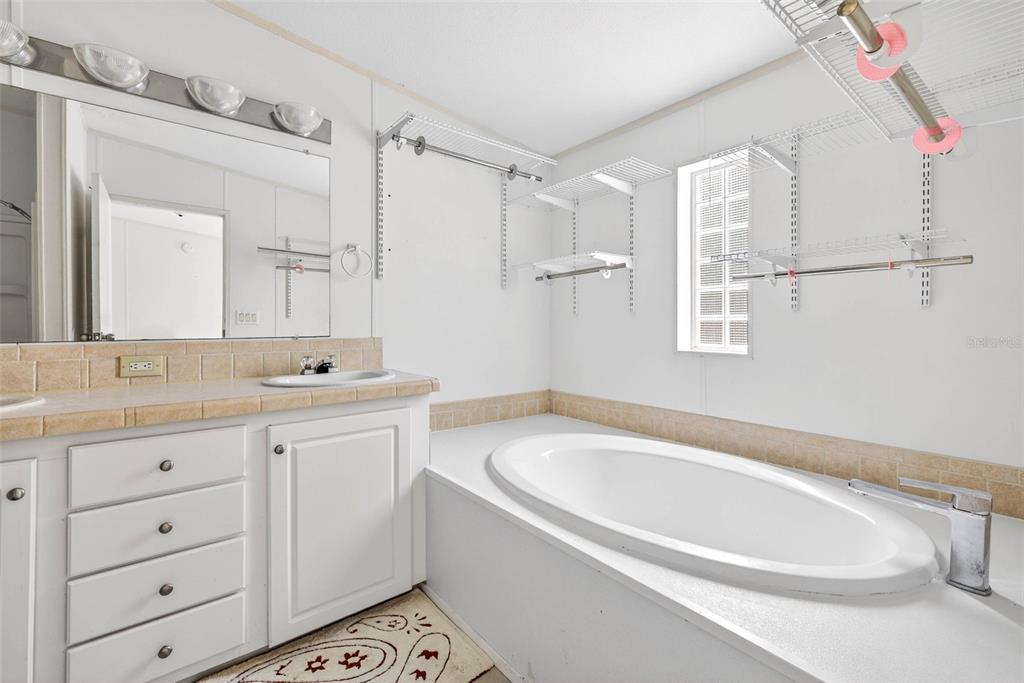6781 West Grant Street Homosassa, FL 34448 - Photo 13 of 24 a bathroom with a granite countertop sink a mirror and a bathtub