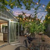 a view of a patio with table and chairs with wooden floor and fence
