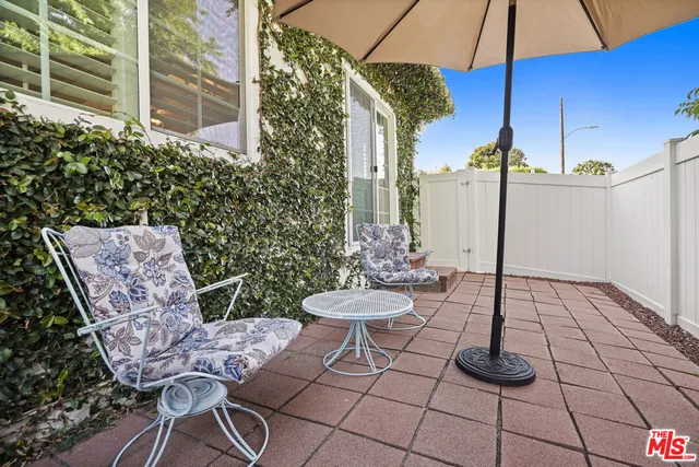 a view of a white house with large windows next to a road