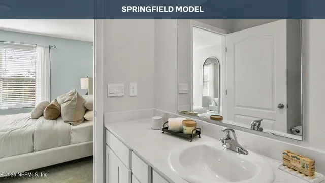 a en suite bathroom with a double vanity sink and mirror