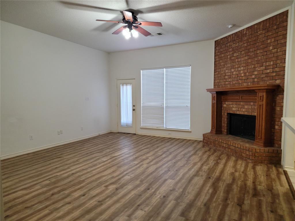 an empty room with windows fireplace and a sink
