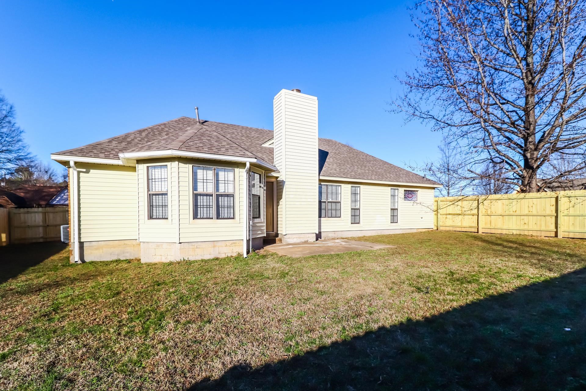 5921 Pecan Trace Memphis, TN 38135 - Photo 14 of 16 Rear view of house with a fenced backyard, a shingled roof, a patio, and a chimney