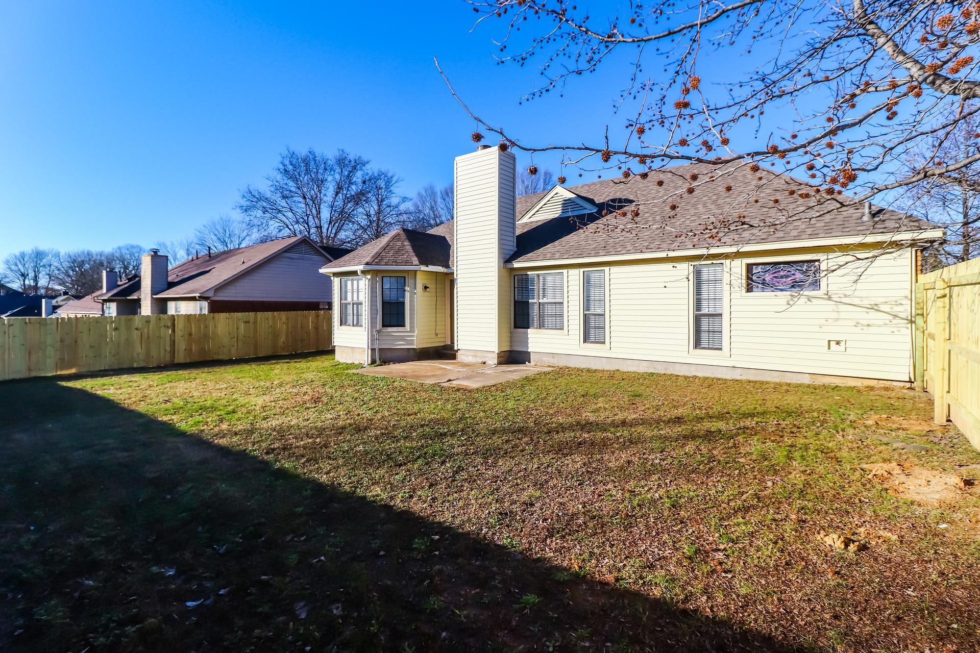 5921 Pecan Trace Memphis, TN 38135 - Photo 15 of 16 Back of house featuring a patio area, a fenced backyard, a chimney, and roof with shingles
