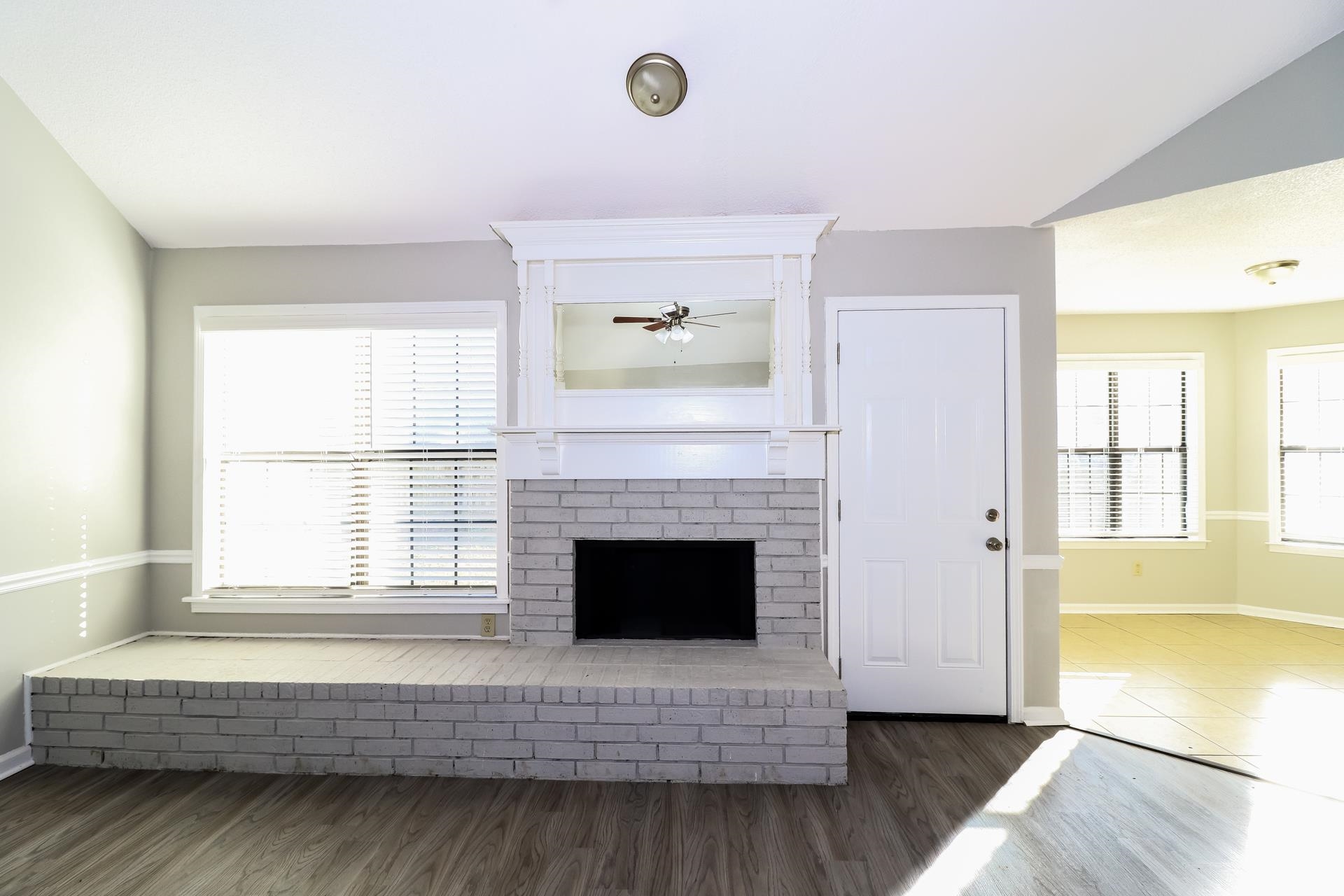 5921 Pecan Trace Memphis, TN 38135 - Photo 4 of 16 Unfurnished living room featuring wood finished floors and a brick fireplace