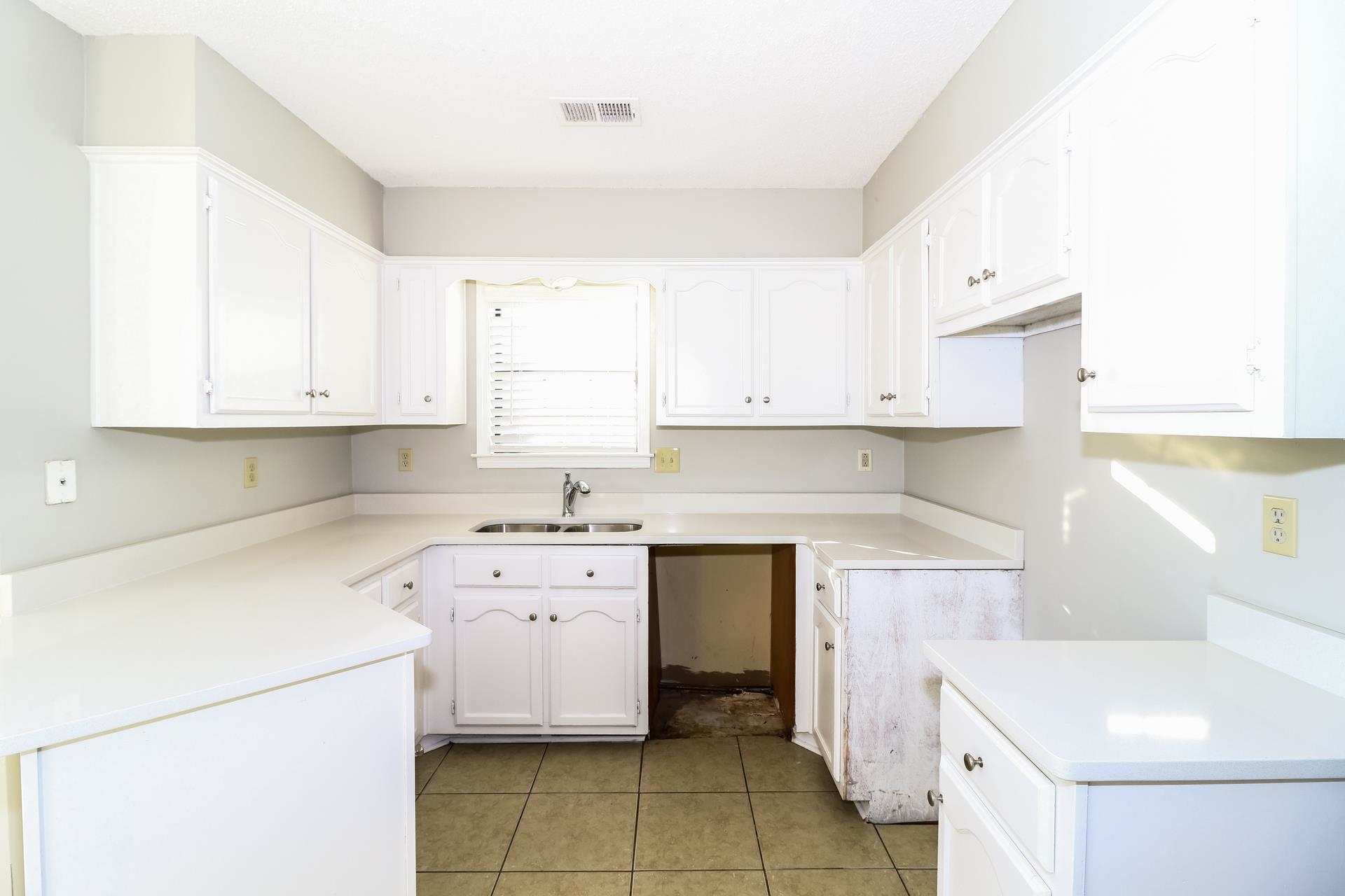 5921 Pecan Trace Memphis, TN 38135 - Photo 7 of 16 Kitchen with light countertops, white cabinetry, and light tile patterned floors