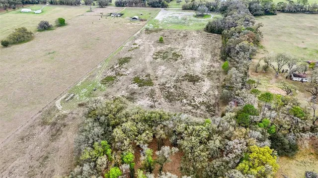 a view of a dry yard with wooden fence