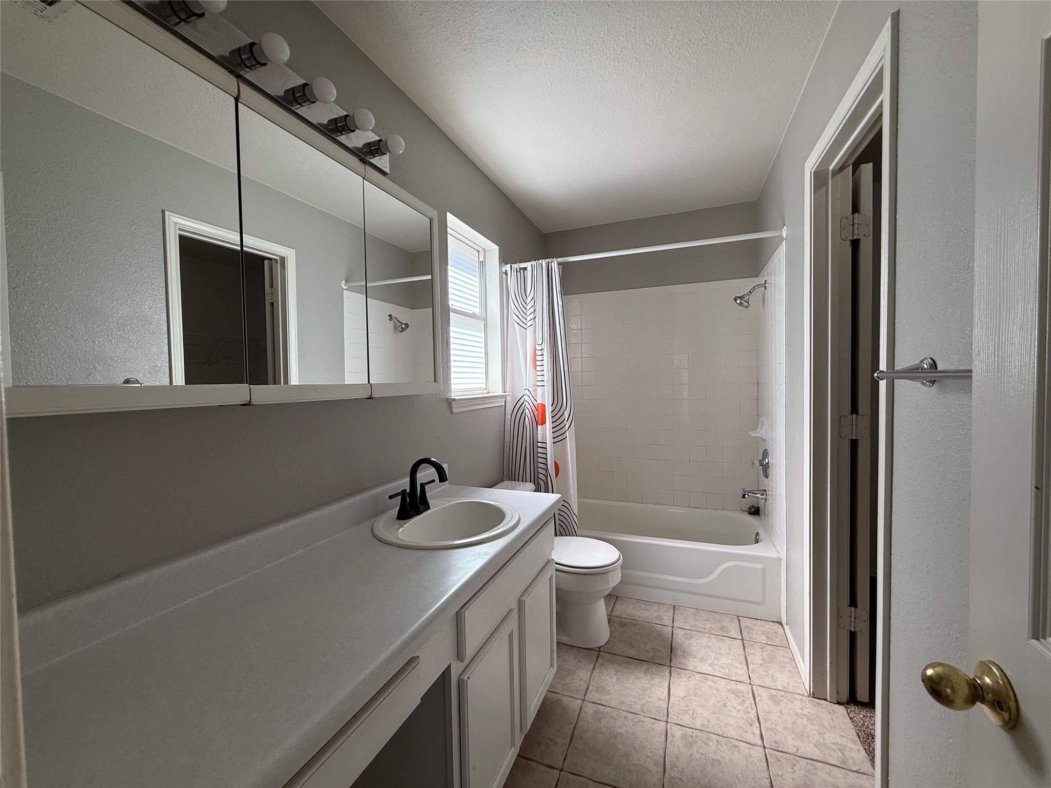 2120 Jester Farms Road Round Rock, TX 78664 - Photo 12 of 28 A well-lit bathroom features a vanity, full-size tub, and tiled flooring.