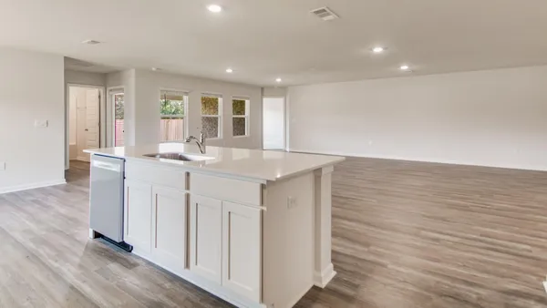a kitchen with stainless steel appliances granite countertop a sink and a wooden floor
