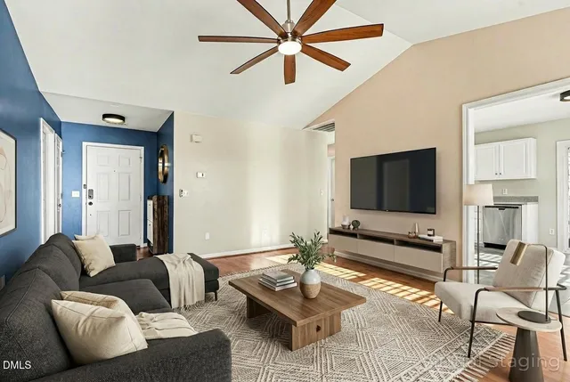 a living room with furniture a flat screen tv and a window
