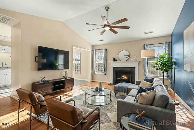a living room with furniture a fireplace and a flat screen tv