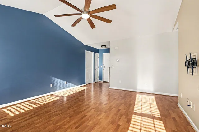 a view of empty room with wooden floor