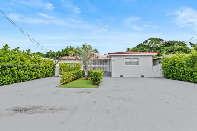 a view of a house with a yard and potted plants