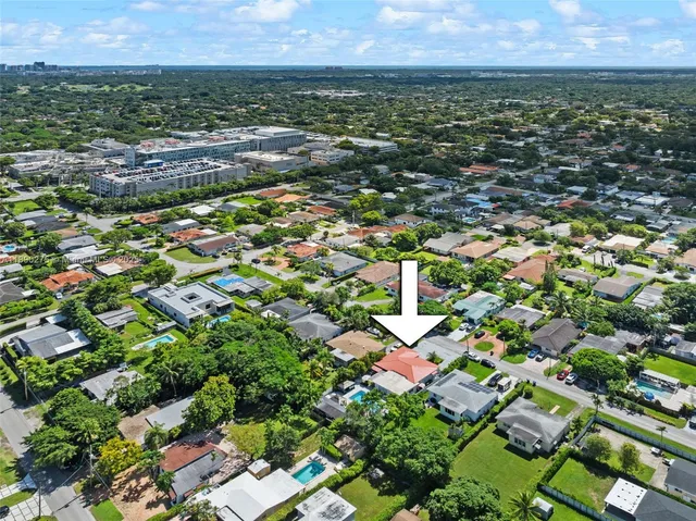 an aerial view of residential houses with outdoor space and trees