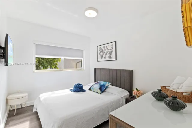 a bedroom with two beds and painting on the wall