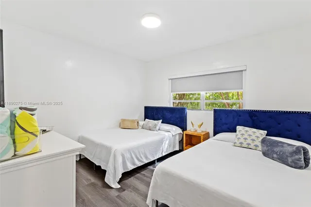 a bedroom with two beds and painting on the wall