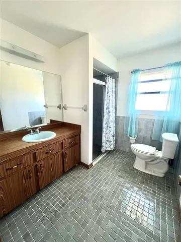 a spacious bathroom with a double vanity sink a toilet and a tub