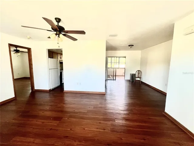 a view of a livingroom with wooden floor and a ceiling fan