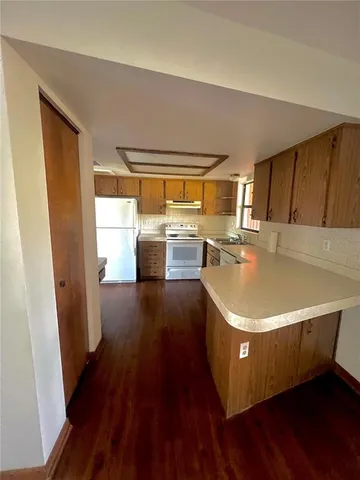 a view of a kitchen with a sink wooden floor and a window