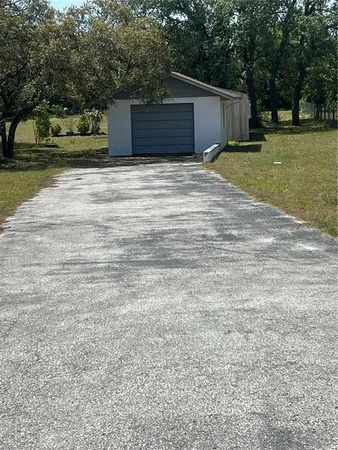 a tall yellow house with a yard