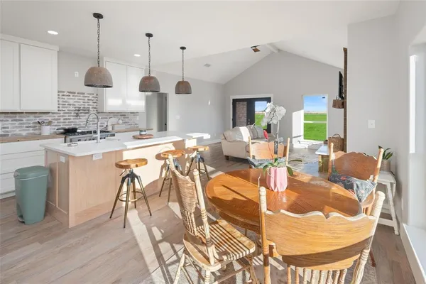 a very nice looking dining room with a large window and stainless steel appliances