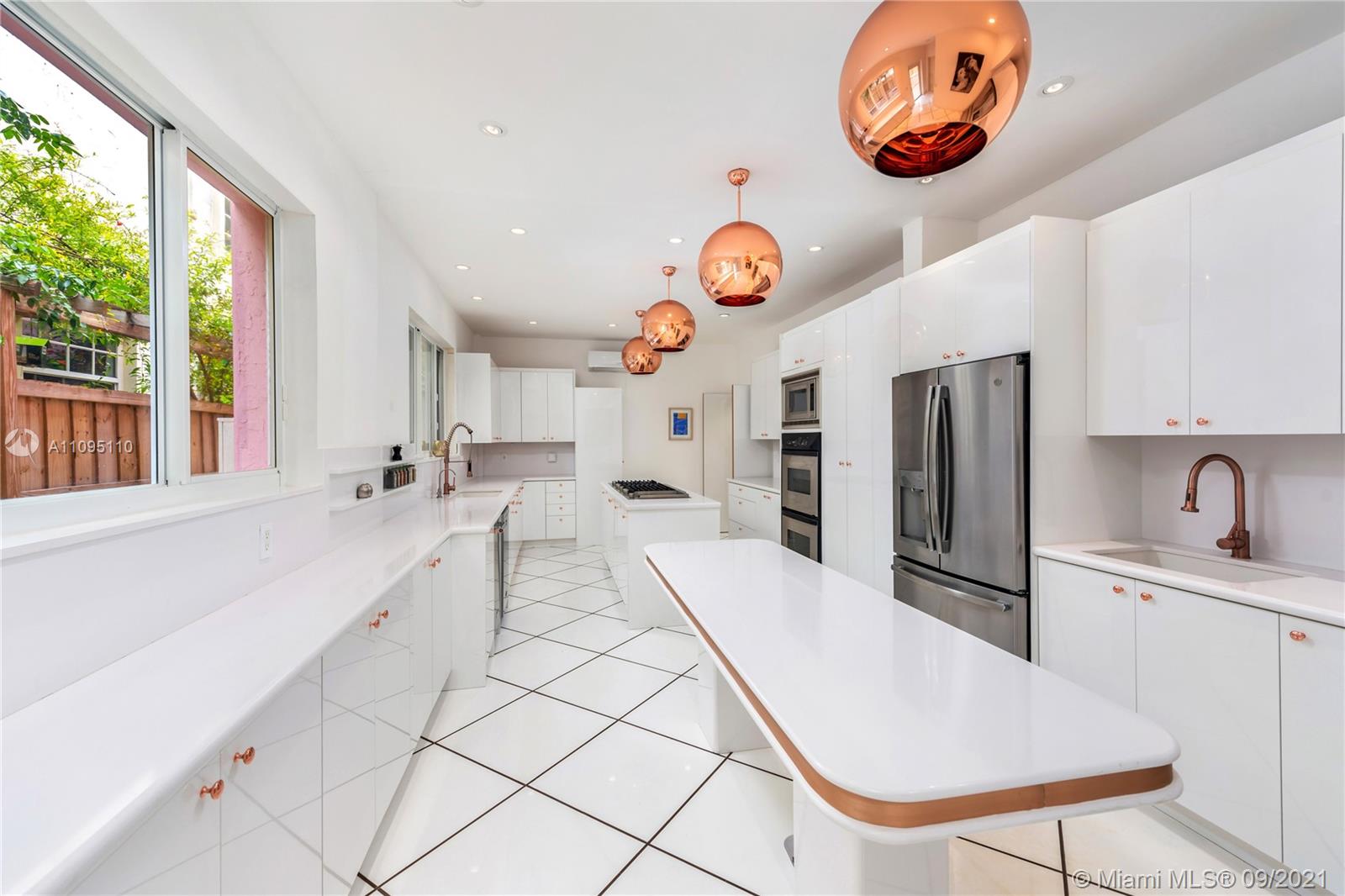 5454 Pine Tree Drive Miami Beach, FL 33140 - Photo 16 of 33 a very nice looking open kitchen with stainless steel appliances kitchen island granite countertop a sink and a white cabinets