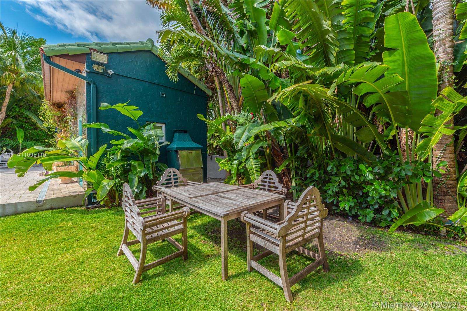 5454 Pine Tree Drive Miami Beach, FL 33140 - Photo 19 of 33 a view of a wooden bench in backyard of the house