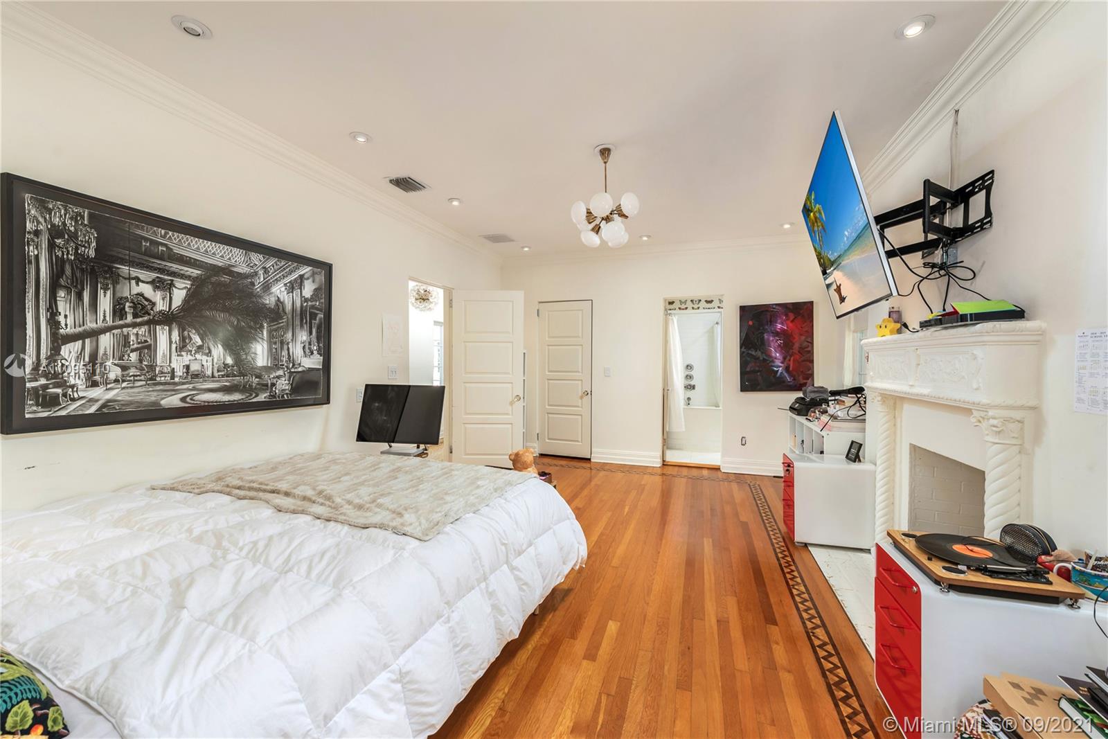 5454 Pine Tree Drive Miami Beach, FL 33140 - Photo 20 of 33 a spacious bedroom with a bed and a fireplace