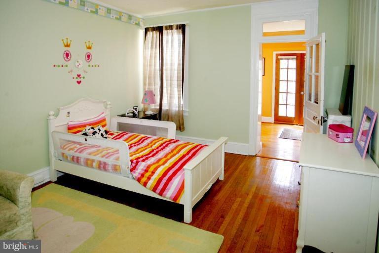 2946 Upton Street Northwest Washington, DC 20008 - Photo 12 of 22 a bedroom with a bed and wooden floor