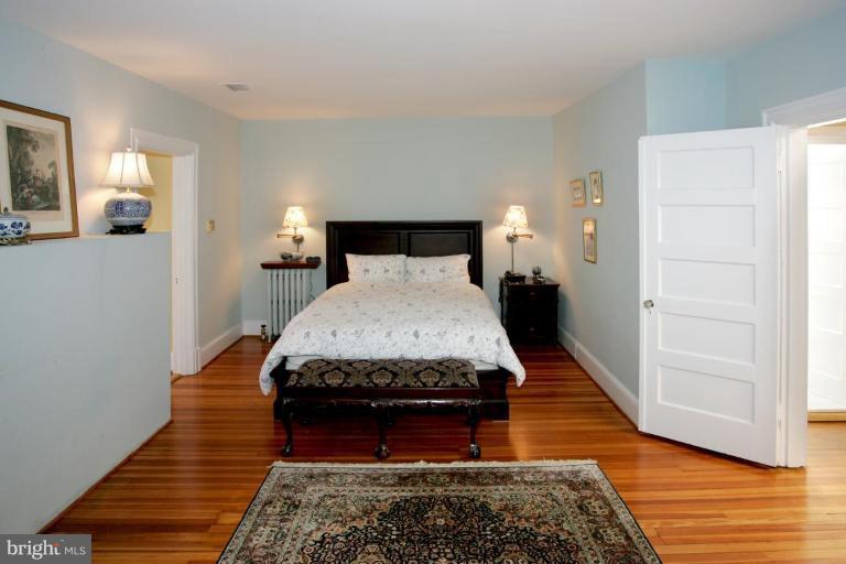 2946 Upton Street Northwest Washington, DC 20008 - Photo 13 of 22 a bedroom with a bed rug and wooden floor