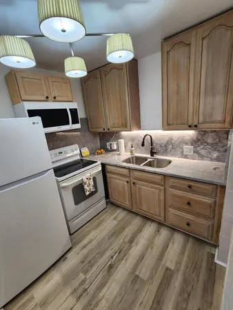 a kitchen with a table chairs and wooden floor