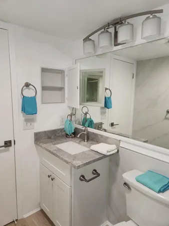 a bathroom with a granite countertop sink and a mirror