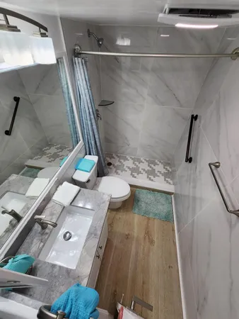 a bathroom with a granite countertop sink a toilet and shower