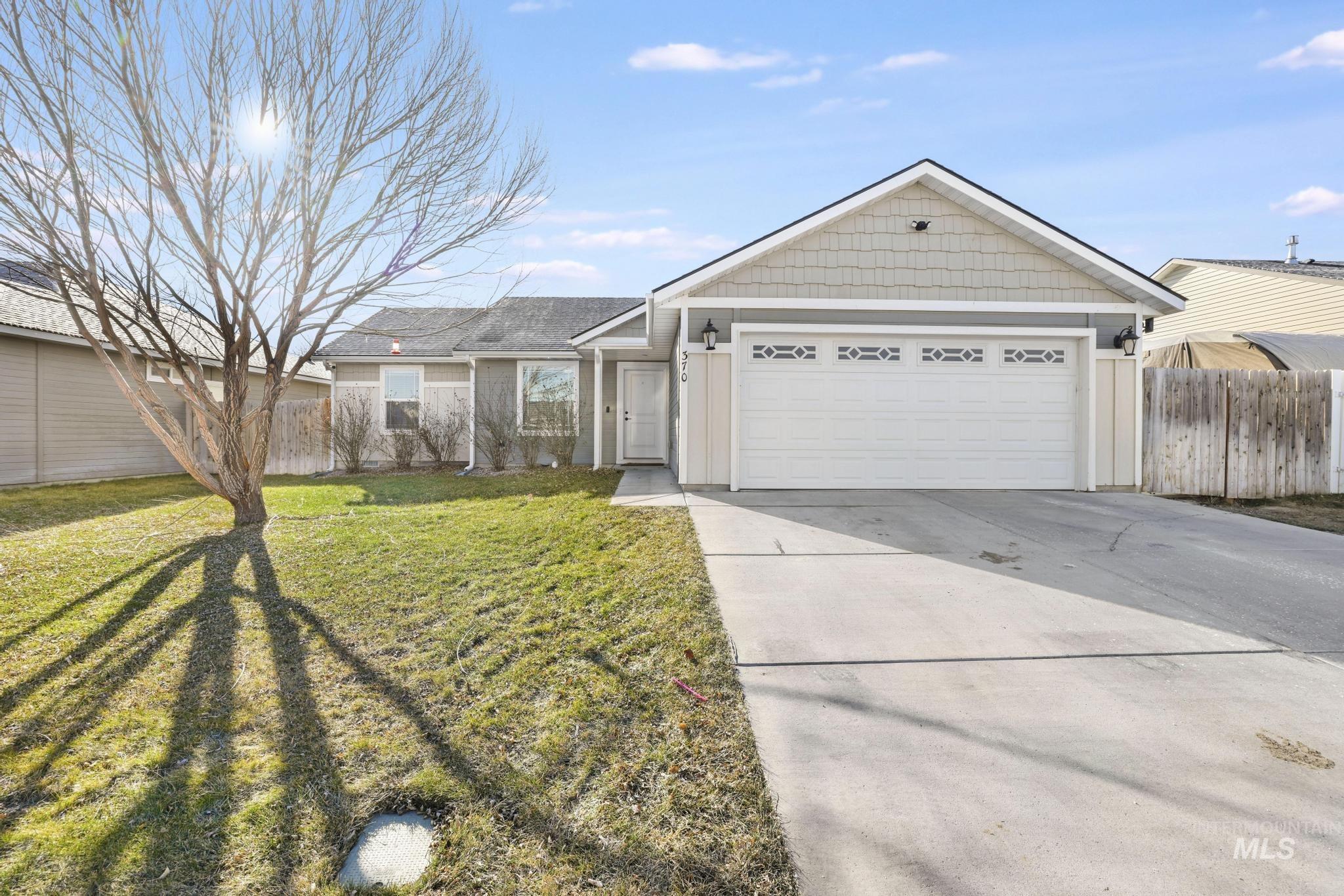 Ranch-style home featuring concrete driveway and an attached garage