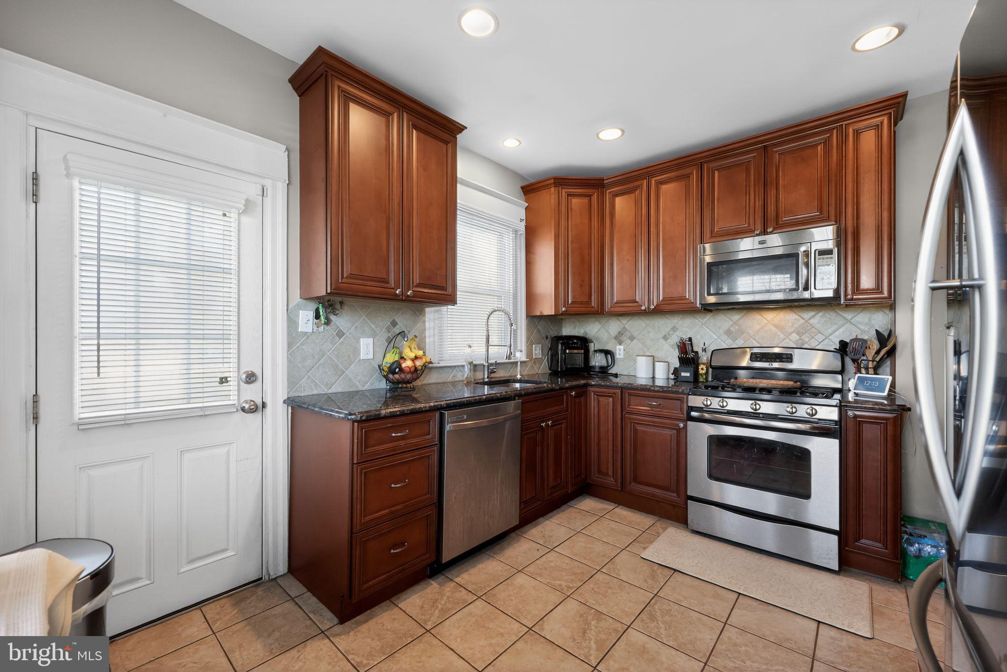 801 Chandler Street Philadelphia, PA 19111 - Photo 12 of 30 a kitchen with stainless steel appliances granite countertop a stove sink and cabinets