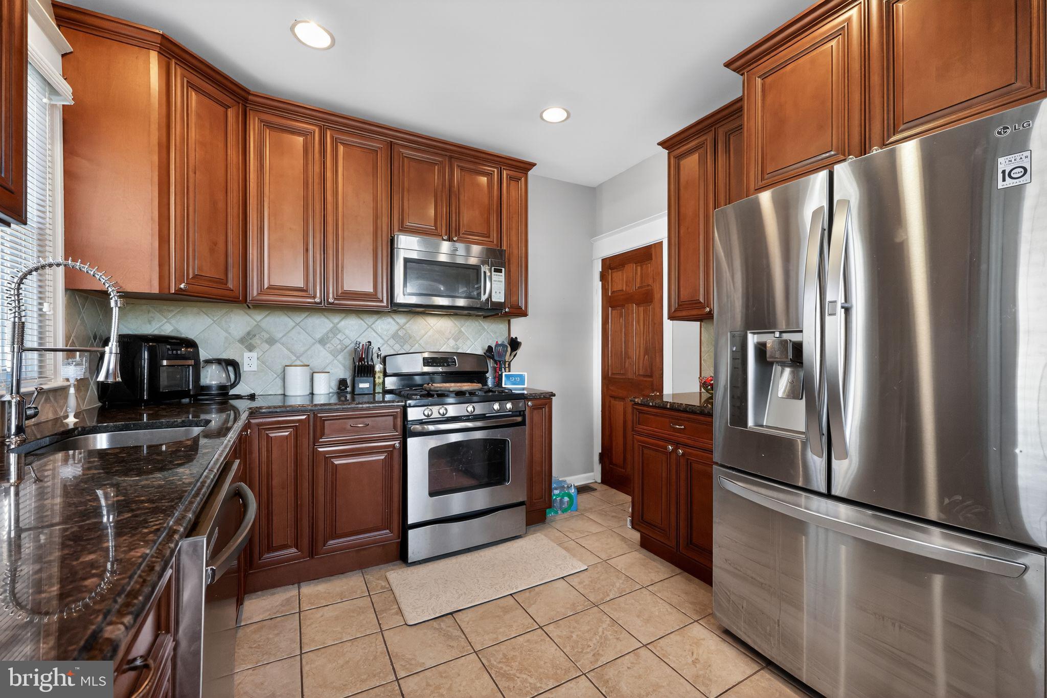 801 Chandler Street Philadelphia, PA 19111 - Photo 13 of 30 a kitchen with stainless steel appliances granite countertop a refrigerator sink and stove