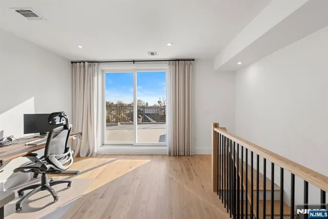 a view of a workspace with wooden floor and a window