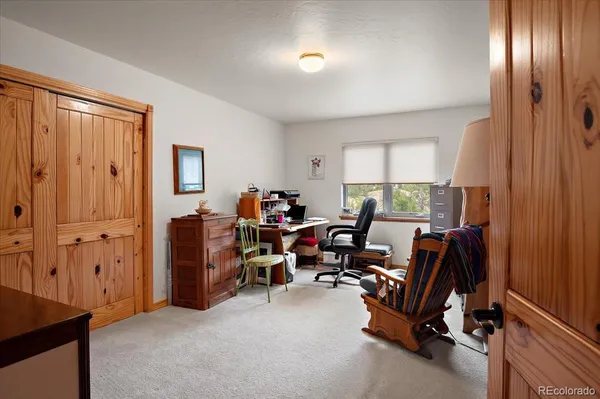 a view of a livingroom with workspace and a window