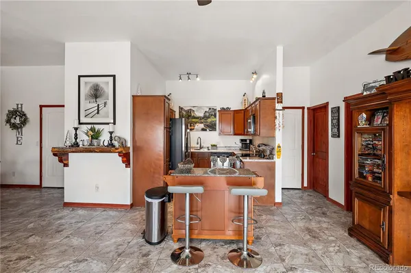 a living room with furniture and a refrigerator