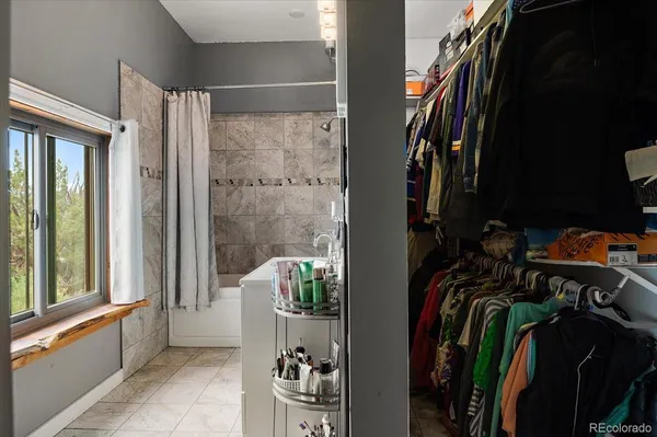 a view of walk in closet with clothes and shoes