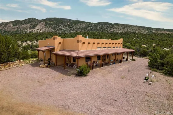 an aerial view of a house with a yard and mountain view