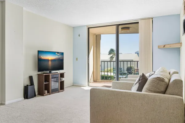 a living room with furniture and a floor to ceiling window