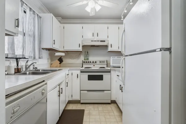 a kitchen with cabinets appliances a sink and a counter top