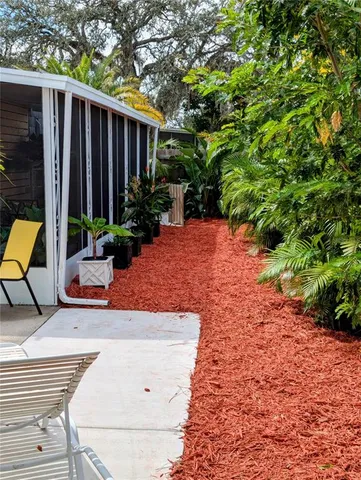 a view of a backyard with plants and wooden fence