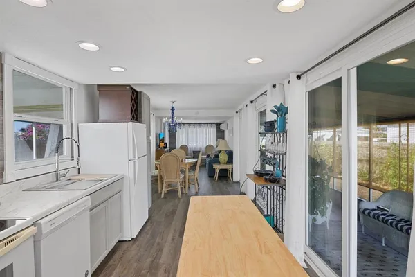 a hallway with white cabinets and stainless steel appliances