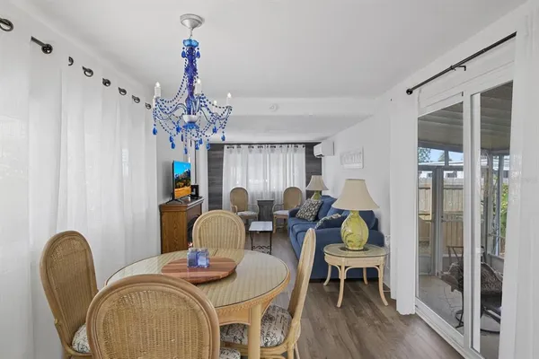 a dining room with furniture a chandelier and wooden floor