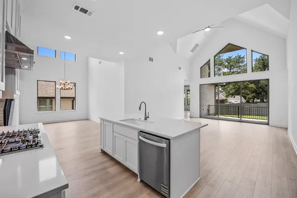 a kitchen with a sink a refrigerator and a stove top oven