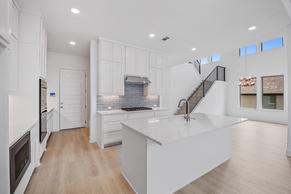 228 Running Fawn Georgetown, TX 78628 - Photo 4 of 29 a kitchen with a sink a refrigerator and a stove top oven