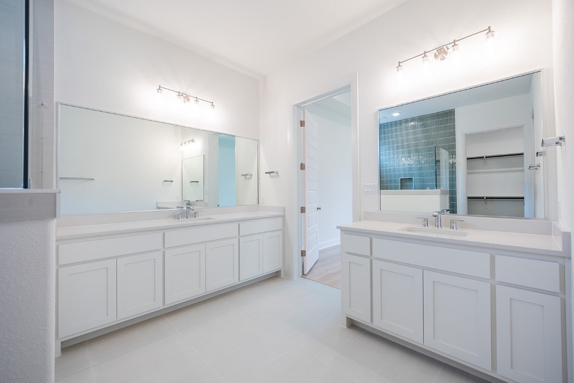 228 Running Fawn Georgetown, TX 78628 - Photo 10 of 29 a spacious bathroom with a double vanity sink a mirror and a bathtub