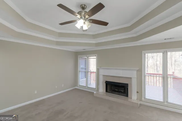 an empty room with fireplace and windows
